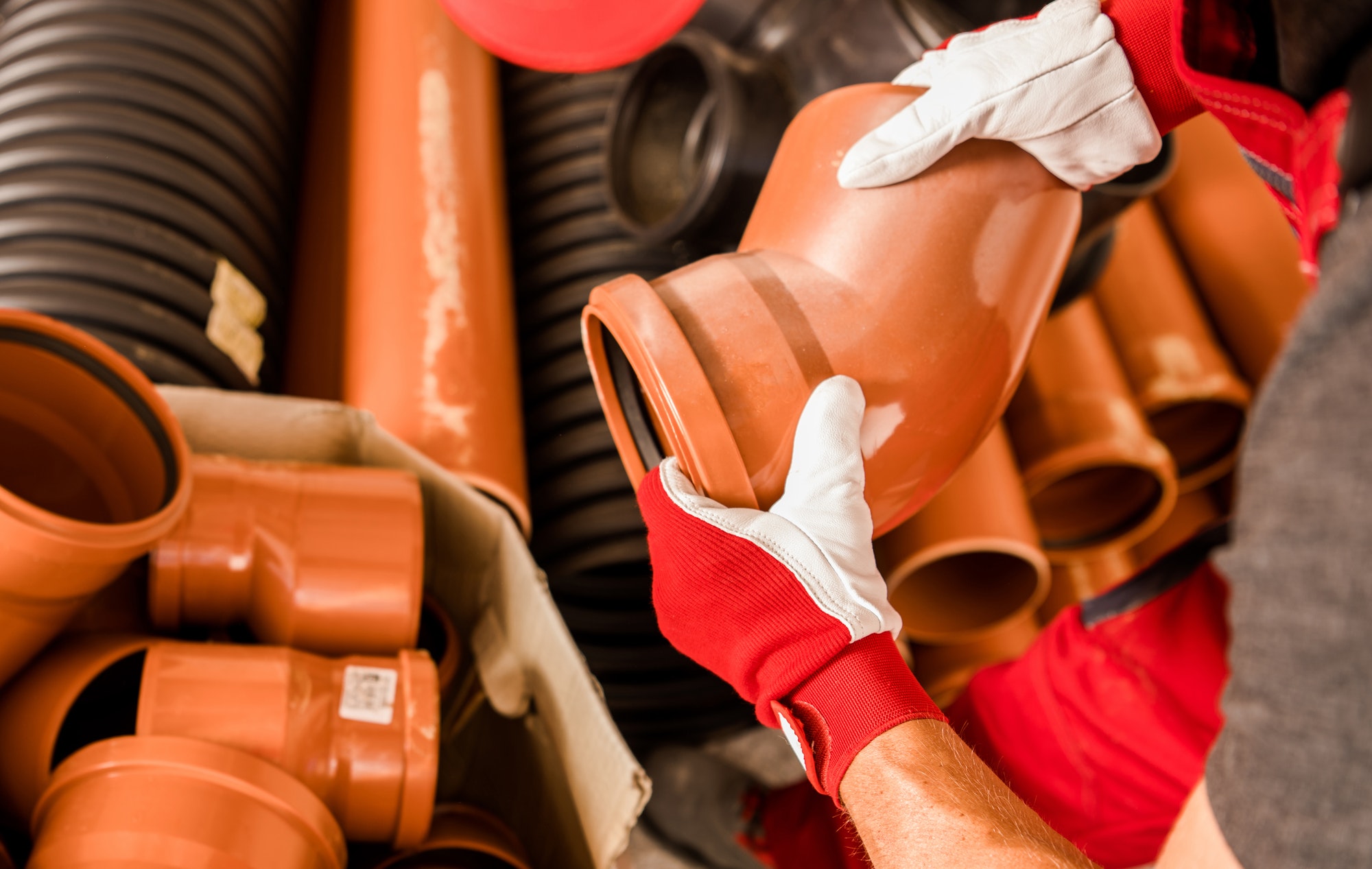 Plumbing Worker with Plastic Septic System Pieces in His Hands