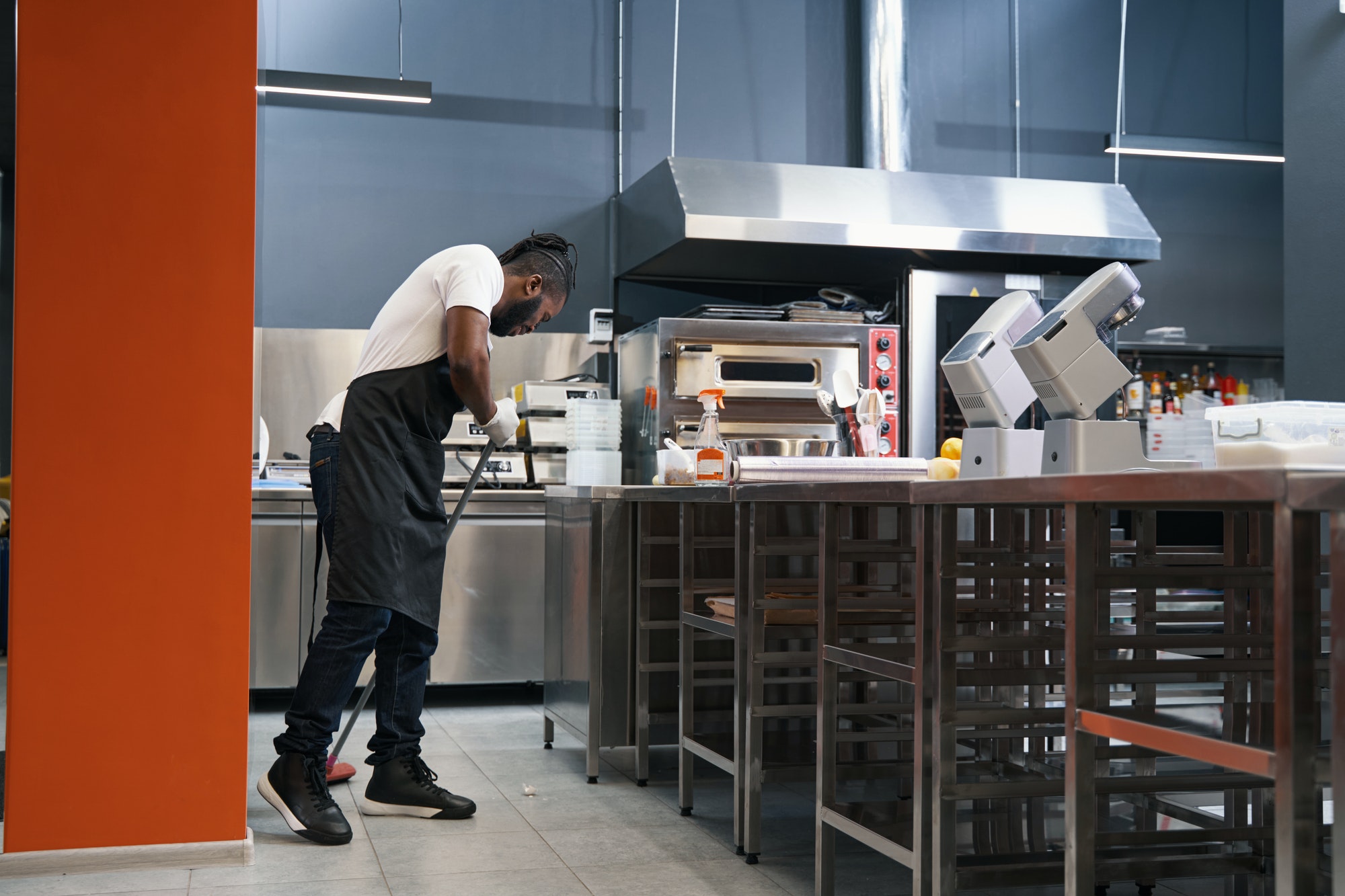 Adult chef cleaning work place in restaurant